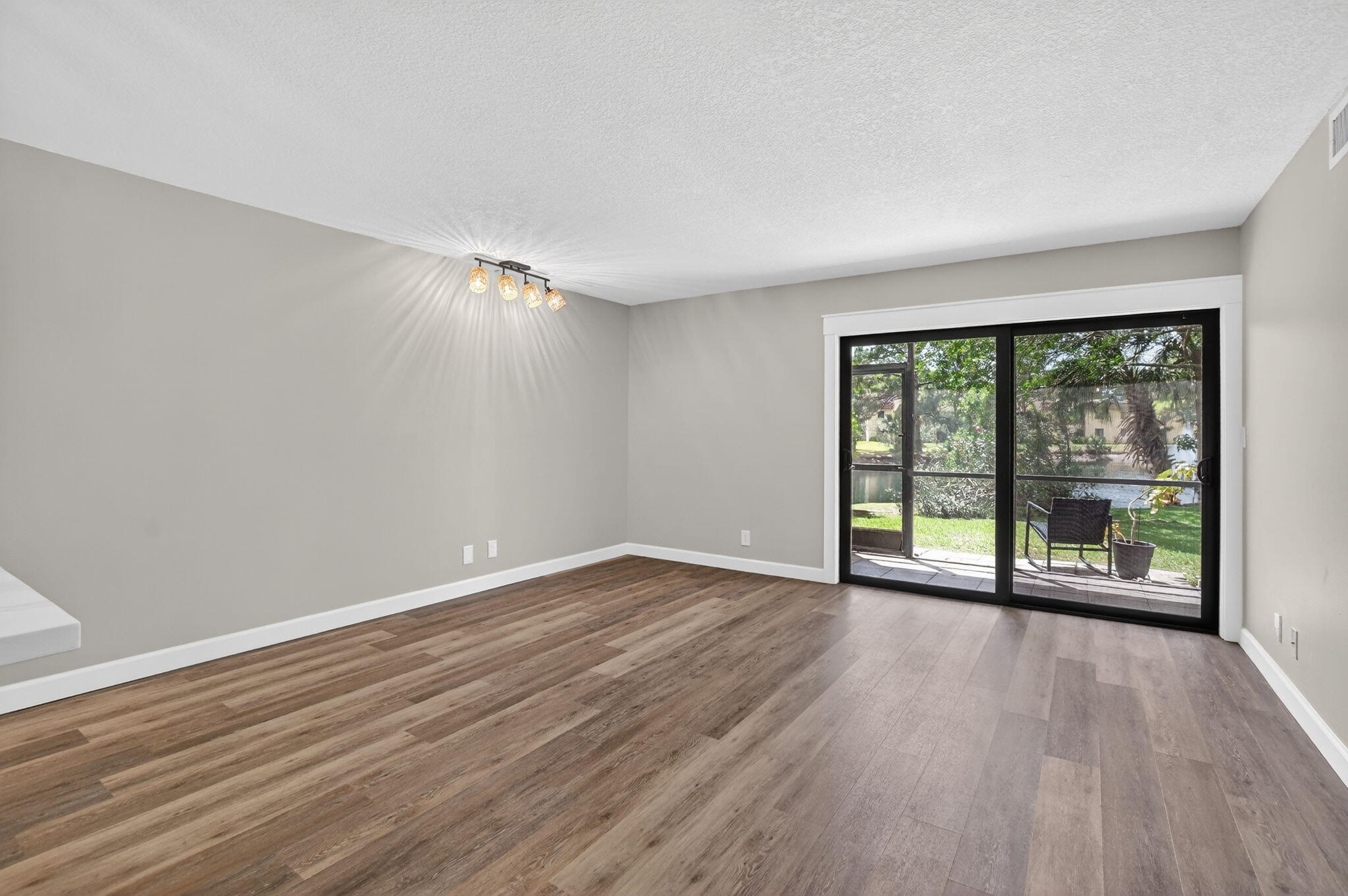 918 Southwest 9th St Circle, Unit 105 Boca Raton, FL 33486 - Photo 11 of 39 a view of an empty room with wooden floor and a window