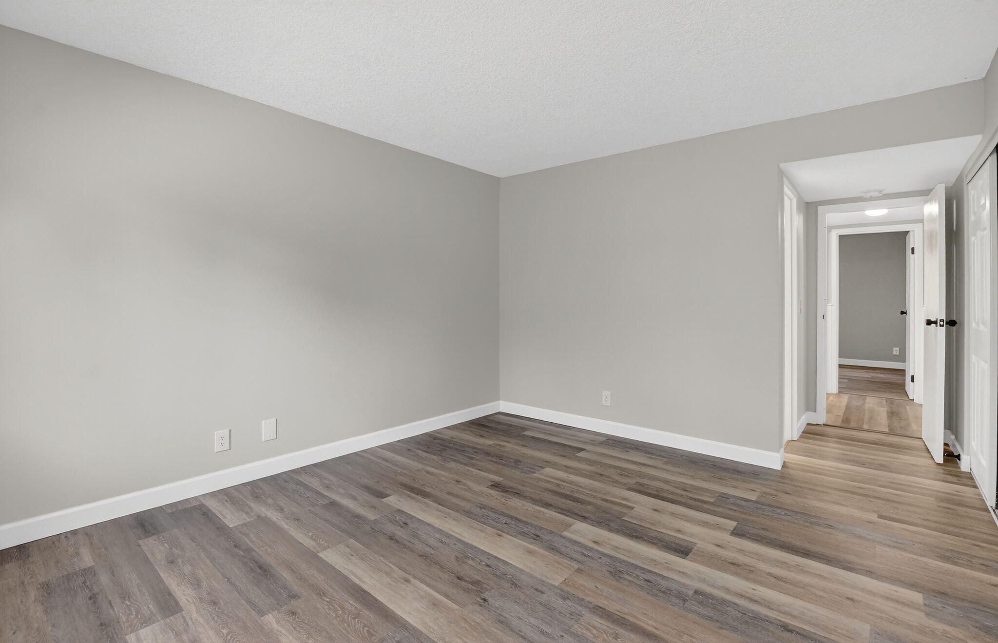 918 Southwest 9th St Circle, Unit 105 Boca Raton, FL 33486 - Photo 15 of 39 a view of an empty room with wooden floor and closet