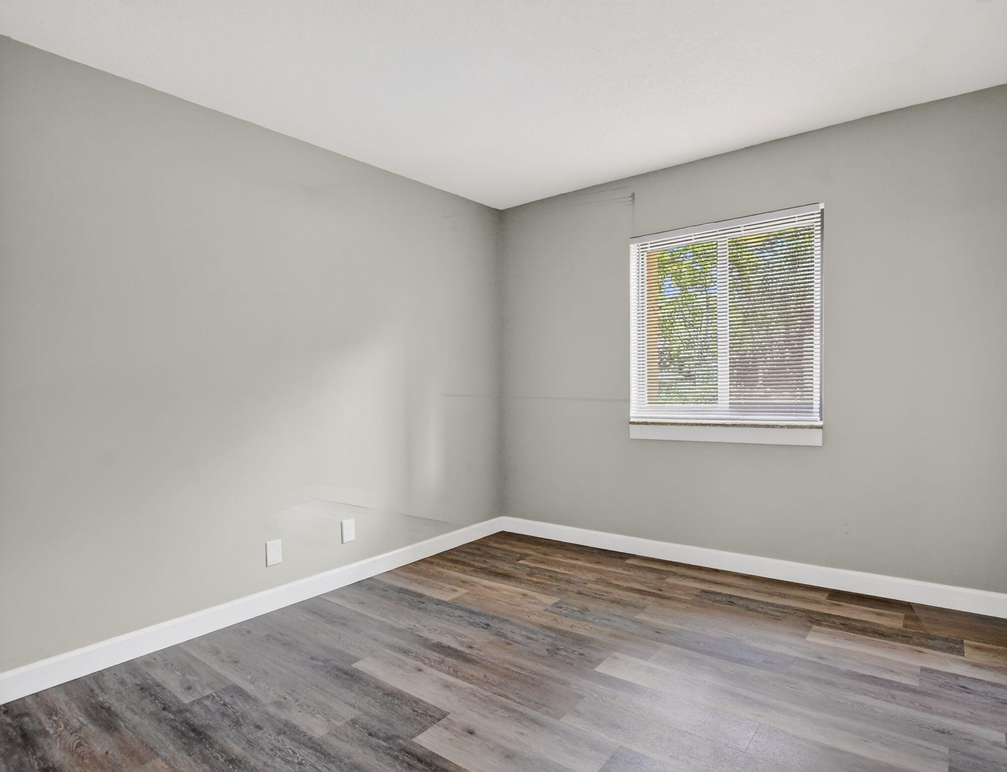 918 Southwest 9th St Circle, Unit 105 Boca Raton, FL 33486 - Photo 18 of 39 a view of an empty room with wooden floor and a window
