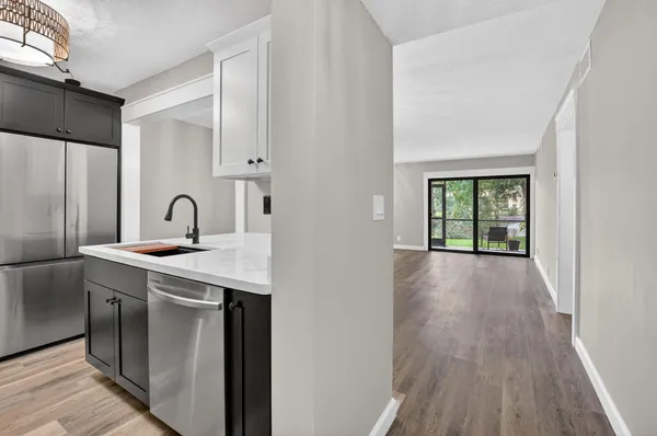 a kitchen with stainless steel appliances a refrigerator a sink a stove and cabinets