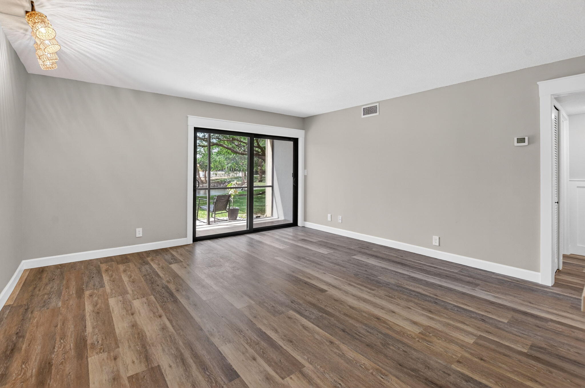 918 Southwest 9th St Circle, Unit 105 Boca Raton, FL 33486 - Photo 9 of 39 a view of an empty room with wooden floor and a window
