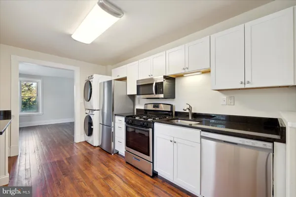 a kitchen with granite countertop a sink and steel appliances