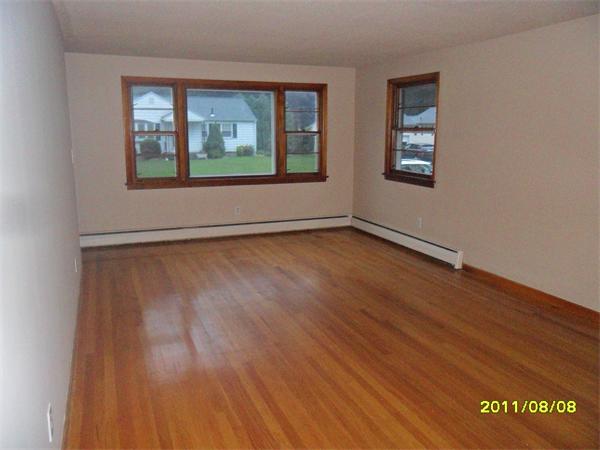 99 Mayher Street Springfield, MA 01104 - Photo 5 of 10 an empty room with wooden floor and windows
