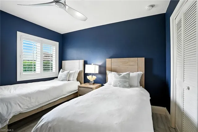 a bedroom with two beds and a night stand