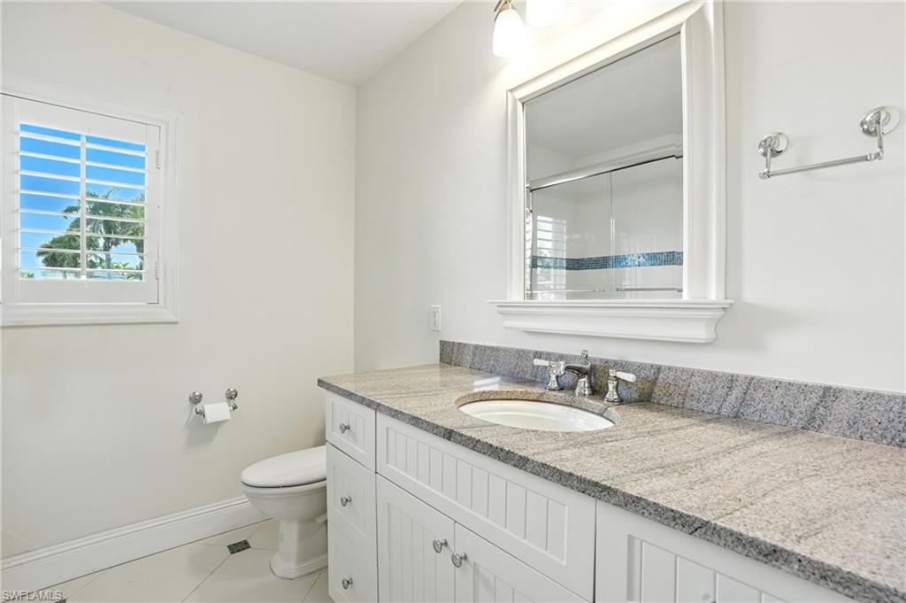 205 Springline Drive Naples, FL 34102 - Photo 16 of 26 a bathroom with a granite countertop sink a toilet and a mirror