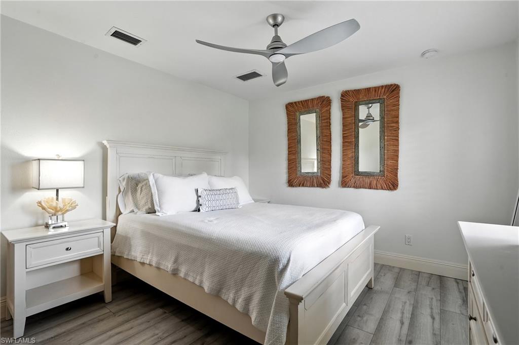 205 Springline Drive Naples, FL 34102 - Photo 17 of 26 a bedroom with a bed and a chandelier