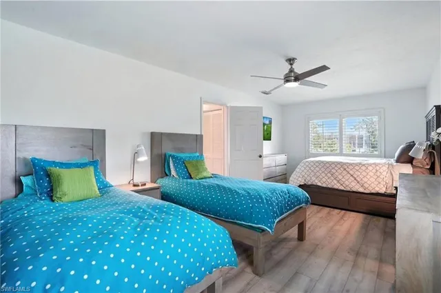 a bedroom with two beds and a large window