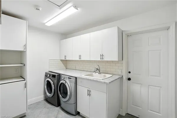 a utility room with cabinets washer and dryer