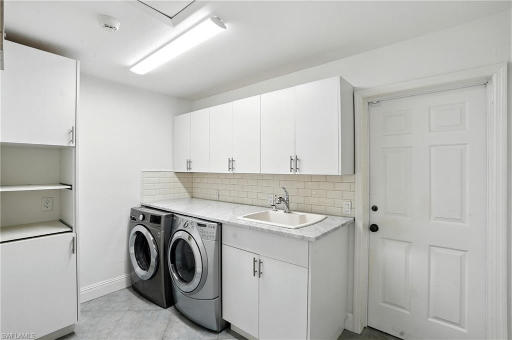205 Springline Drive Naples, FL 34102 - Photo 20 of 26 a utility room with cabinets washer and dryer
