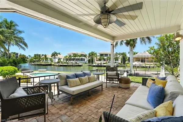 a living room with patio furniture and a potted plant