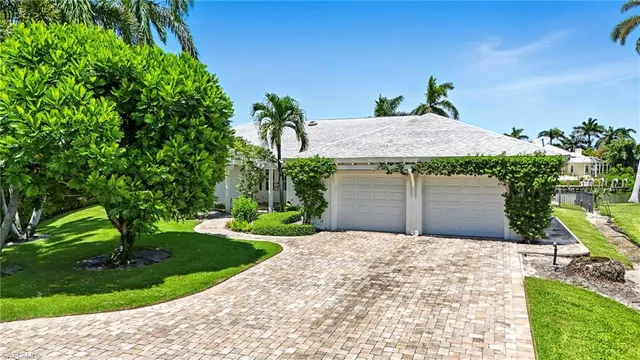 a front view of a house with a yard and potted plants