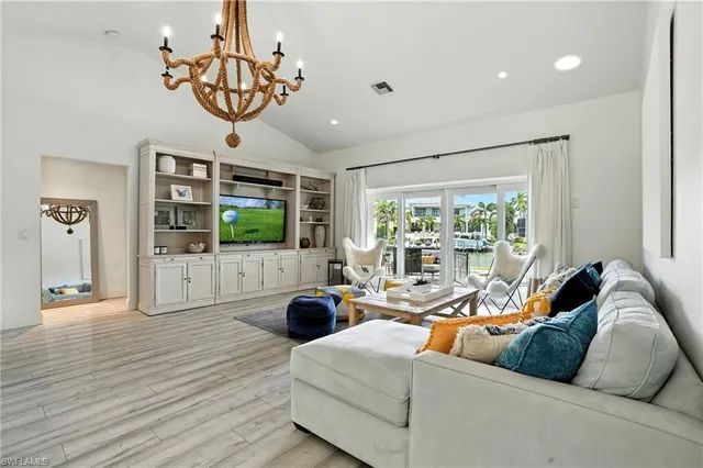 a living room with furniture large window and wooden floor