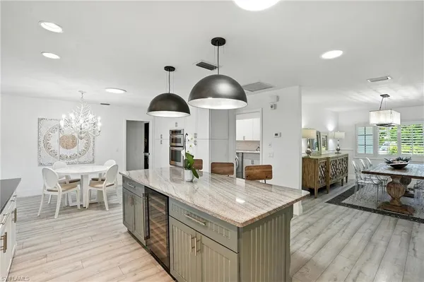 a kitchen with a dining table chairs wooden floor and appliances