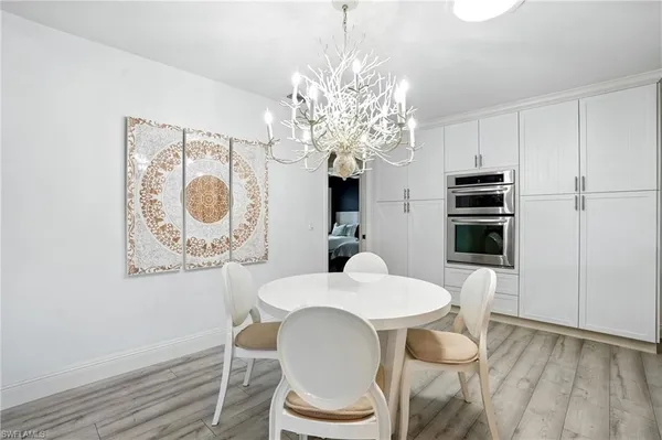 a dining room with furniture a chandelier and wooden floor