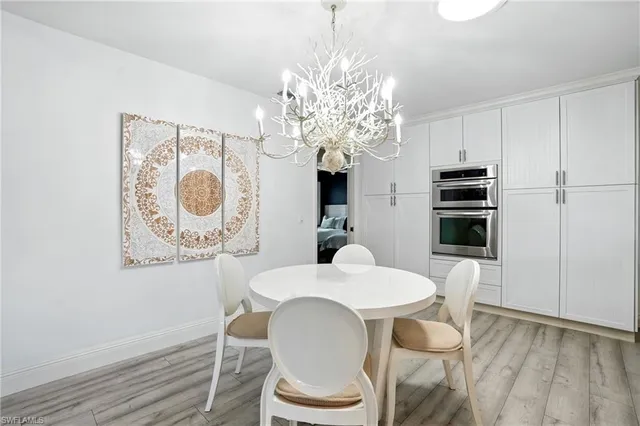 a dining room with furniture a chandelier and wooden floor