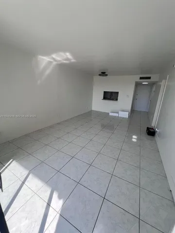 a view of a room with an empty space and a window