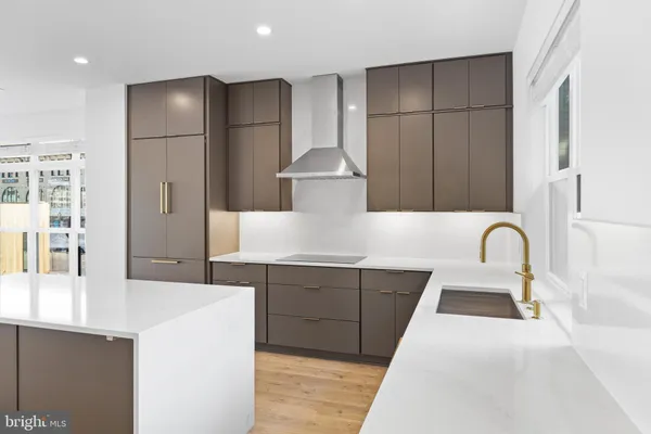 a large kitchen with stainless steel appliances granite countertop a sink a stove and a refrigerator