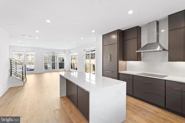 a large kitchen with stainless steel appliances a large counter top a stove a refrigerator and a sink