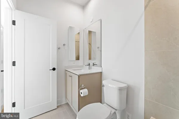 a bathroom with a toilet a sink and mirror