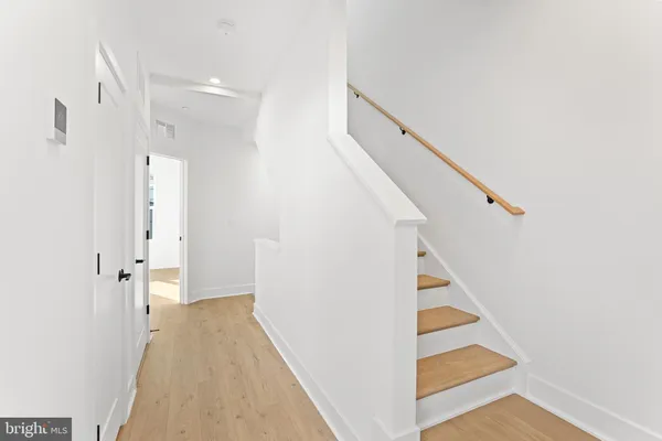 a view of a hallway with white walls and entryway