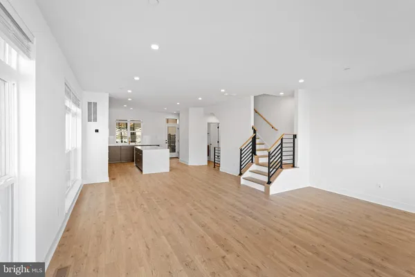 a view of a living room and kitchen with furniture wooden floor and windows