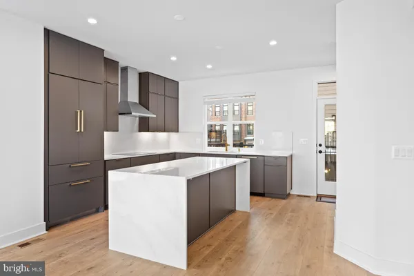 a kitchen with stainless steel appliances granite countertop a refrigerator a sink dishwasher a stove and a refrigerator with wooden floor