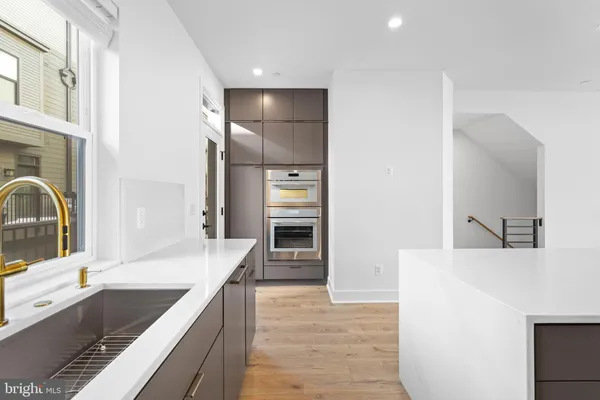 a kitchen with stainless steel appliances kitchen island a stove a sink and a refrigerator