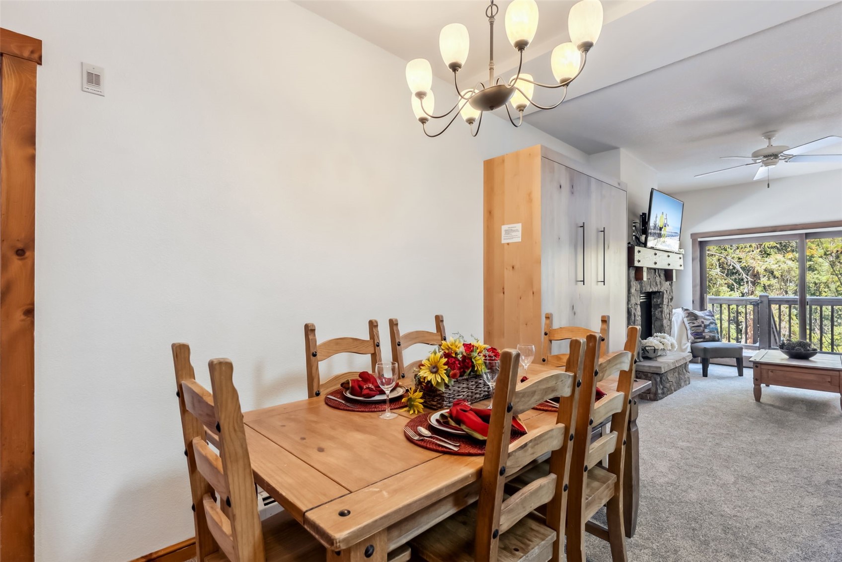 17 Lake Ridge Circle, Unit 1826 Keystone, CO 80435 - Photo 5 of 28 Carpeted dining space featuring ceiling fan with notable chandelier, a stone fireplace, and visible vents