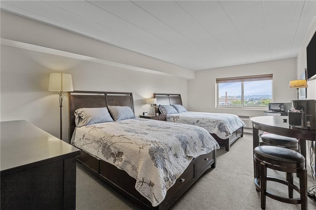 5 Bayard Road, Unit 307 Pittsburgh, PA 15213 - Photo 19 of 20 a bedroom with a bed a table and chair