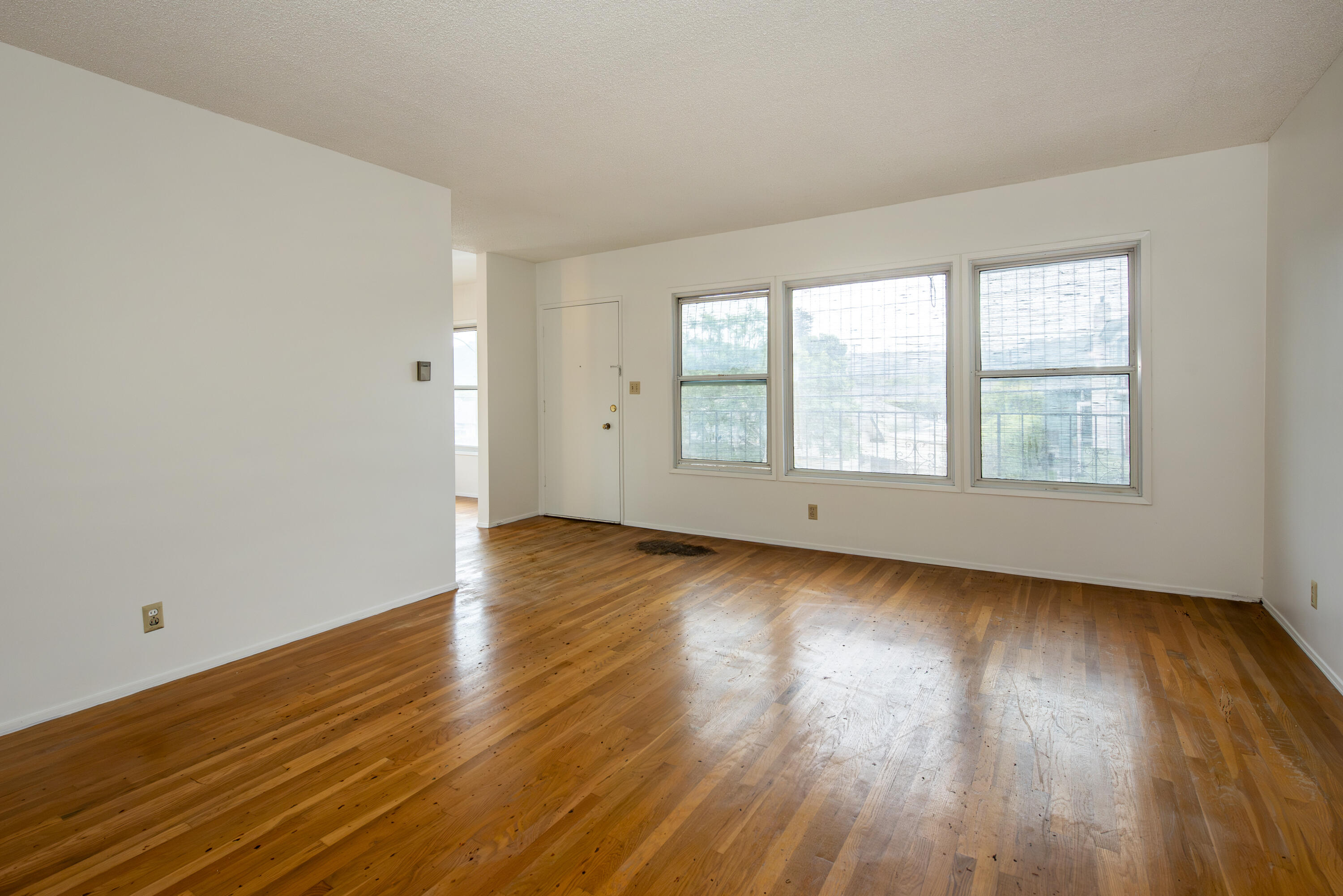 1308 Bath Street Santa Barbara, CA 93101 - Photo 4 of 19 an empty room with wooden floor and windows