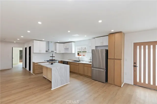 a kitchen with stainless steel appliances granite countertop a refrigerator stove top oven and refrigerator