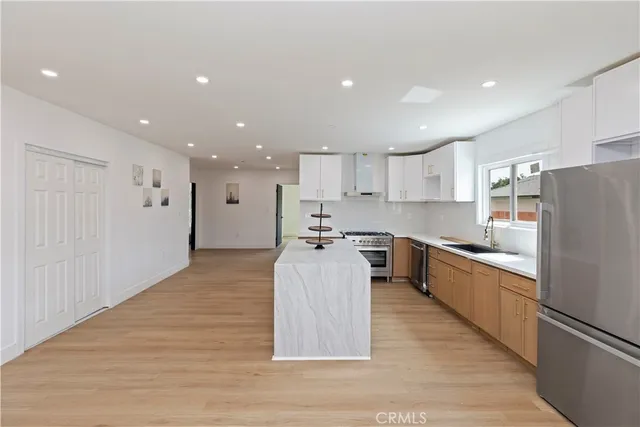 a large kitchen with stainless steel appliances granite countertop a large counter top and a stove top oven