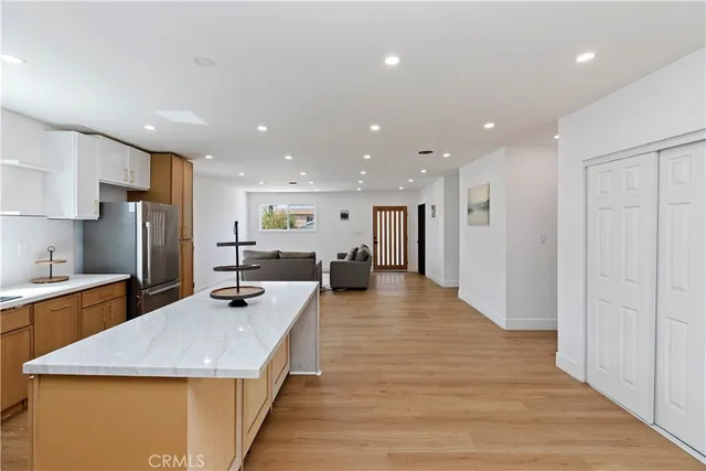 a large kitchen with stainless steel appliances lots of counter space and wooden floor