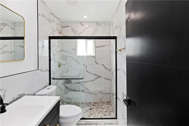 a bathroom with a toilet a sink and glass door