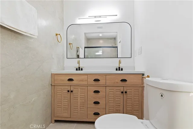 a bathroom with a double vanity sink mirror and toilet