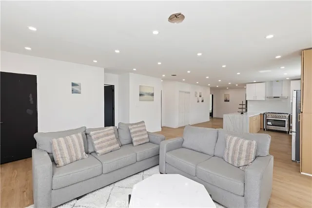 a living room with furniture kitchen area and a couch