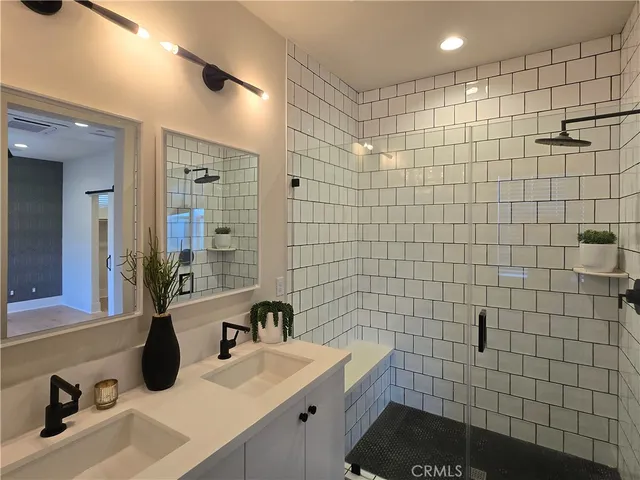 a bathroom with a sink shower and a mirror