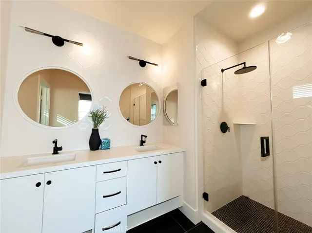 a bathroom with a double vanity sink mirror and shower
