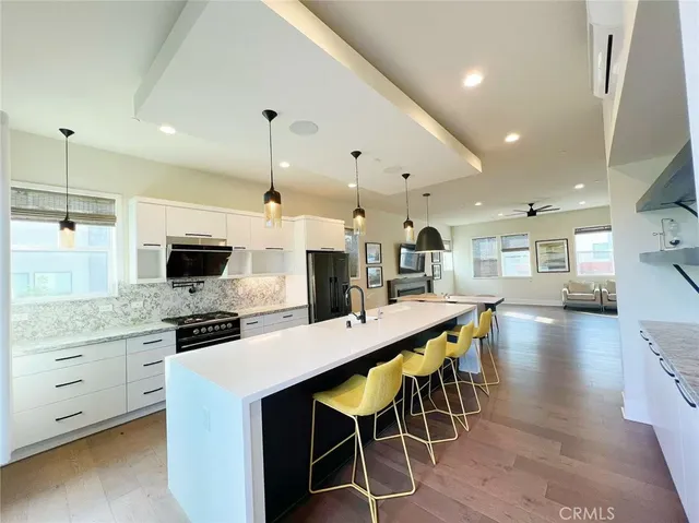 a kitchen with stainless steel appliances kitchen island granite countertop a table chairs sink and cabinets
