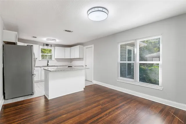 a kitchen with a refrigerator and white cabinets