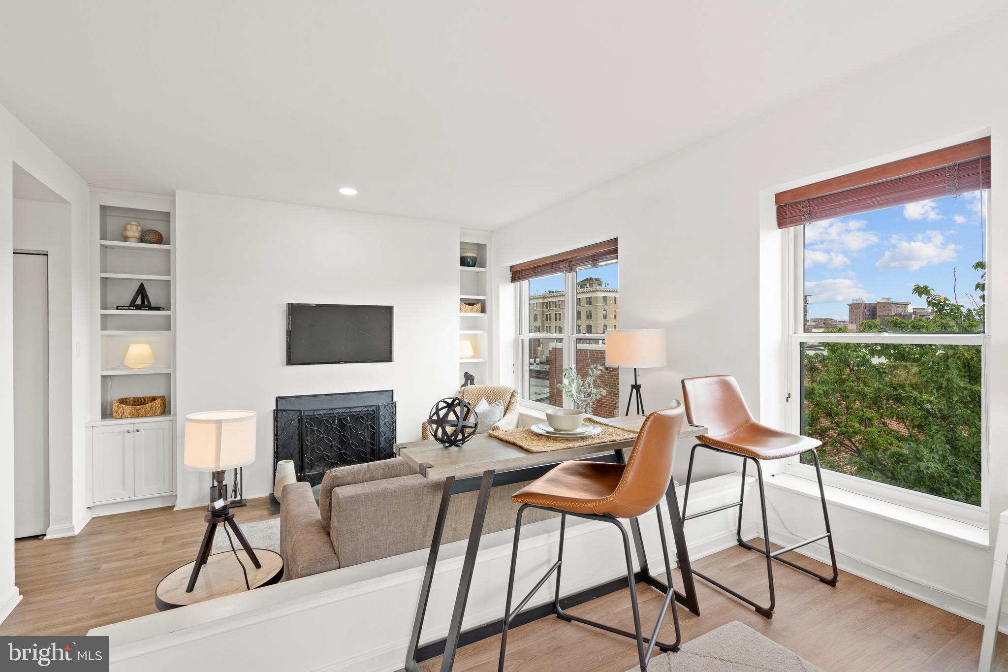 1736 Willard Street Northwest, Unit 506 Washington, DC 20009 - Photo 14 of 28 a living room with furniture a flat screen tv and a fireplace