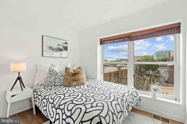 a bedroom with furniture and a large window