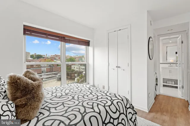 a bedroom with a bed and a large window with outer view