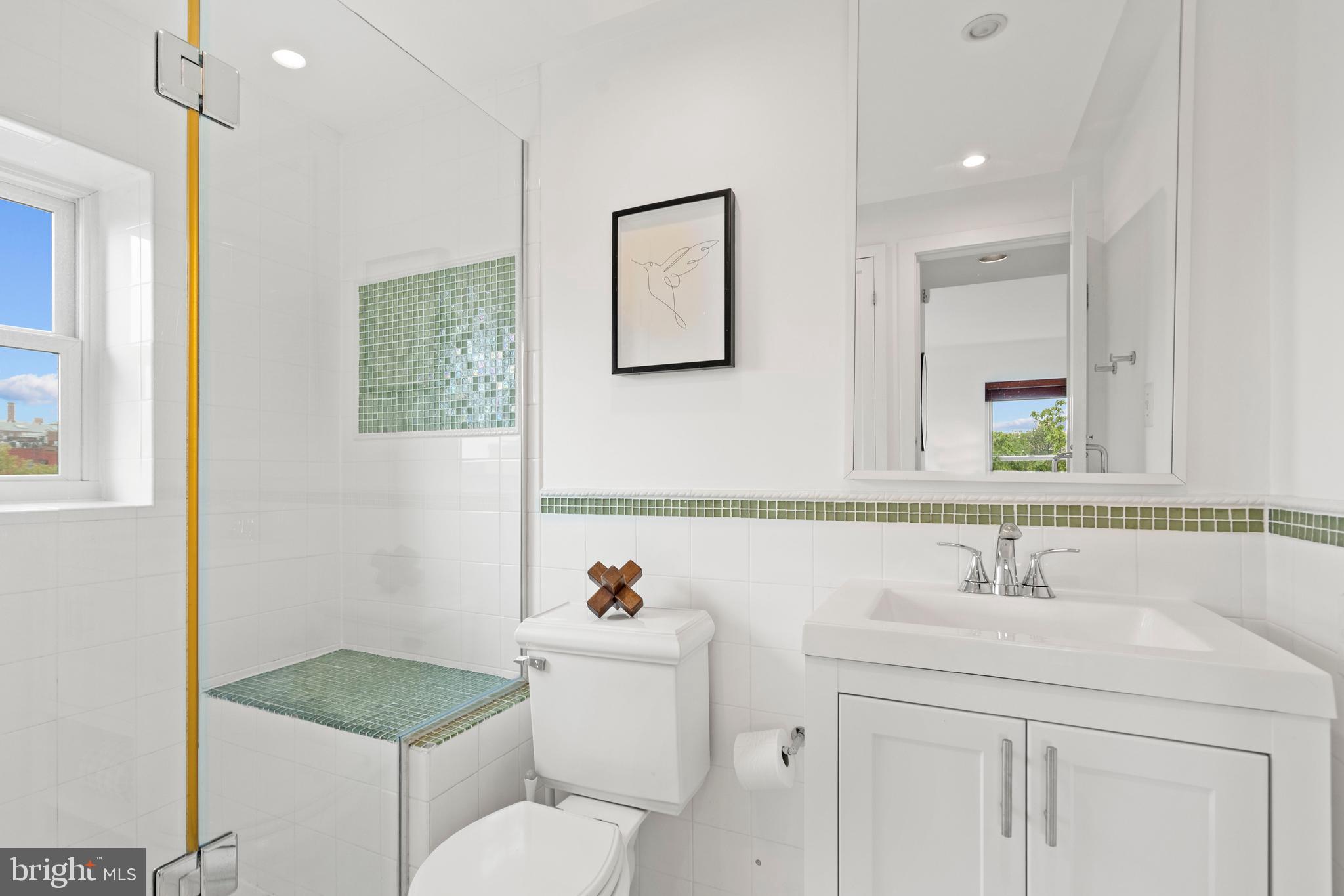 1736 Willard Street Northwest, Unit 506 Washington, DC 20009 - Photo 21 of 28 a bathroom with a granite countertop toilet sink and mirror
