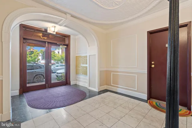 a view of a hallway with dining room and furniture