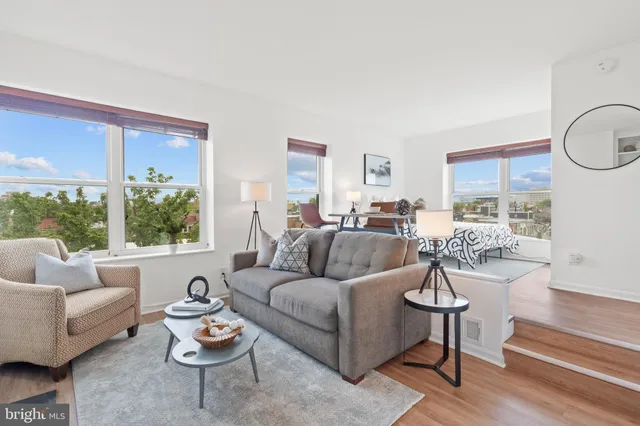 a living room with furniture fireplace and a large window