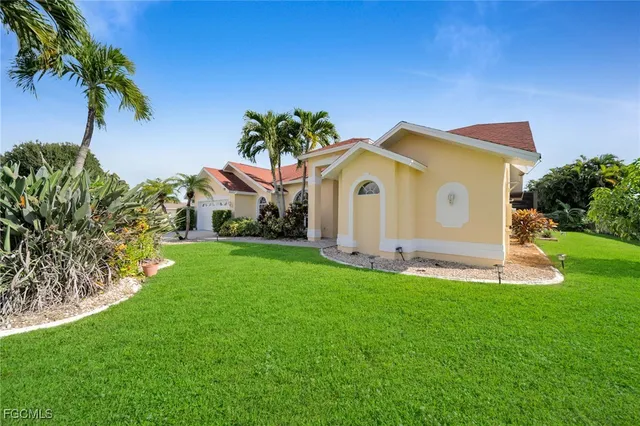 a view of a house with a yard and potted plants