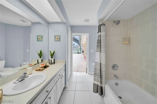 a bathroom with a tub a sink and a large mirror