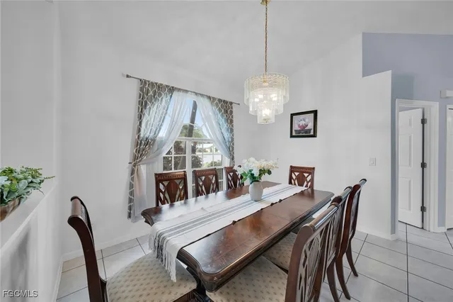 a dining room with furniture a chandelier and wooden floor
