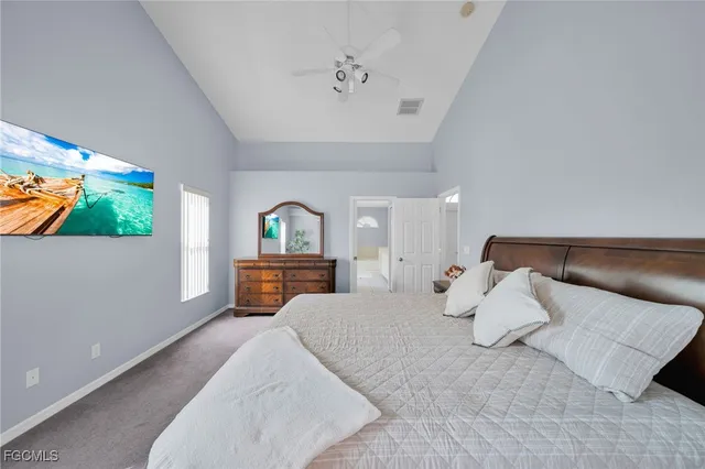 a bedroom with a bed and a flat tv screen on dresser
